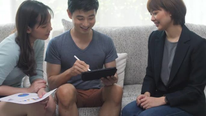 亚洲年轻夫妇客户签署保险合同握手