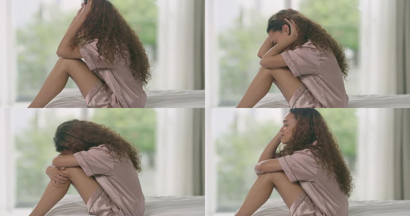 4k视频片段，一名年轻女子在家里的床上看起来不开心