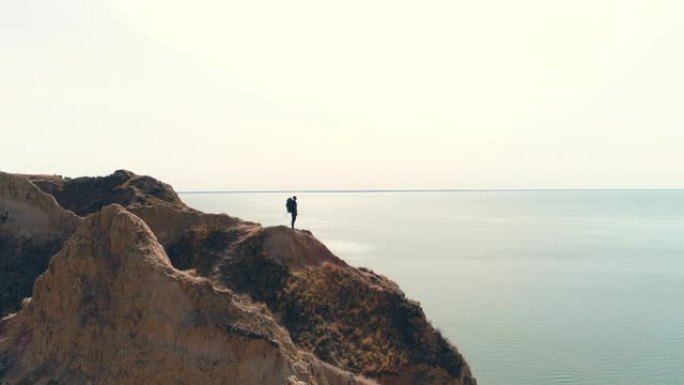 游客站在海景背景上的山崖上