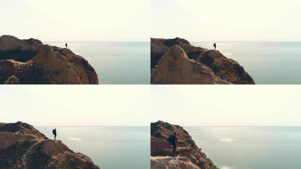 游客站在海景背景上的山崖上
