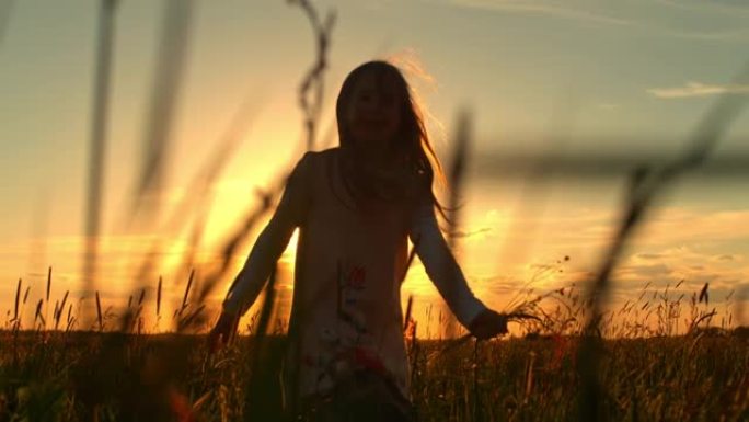 日落时分，SLO MO小女孩在草地上奔跑