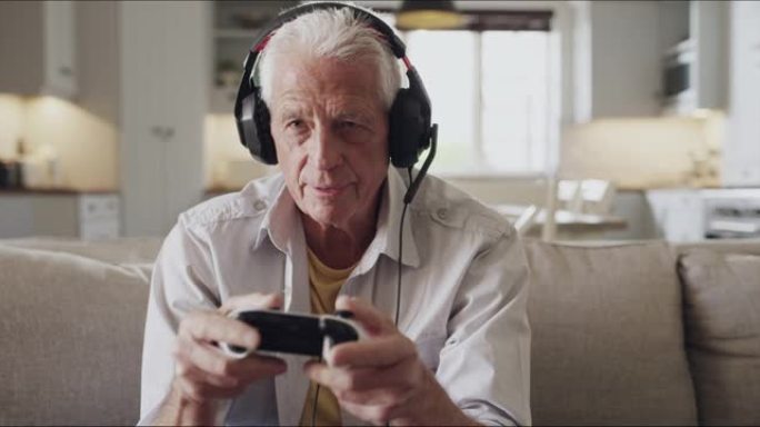一名老人在家玩电子游戏时戴着耳机的4k视频片段