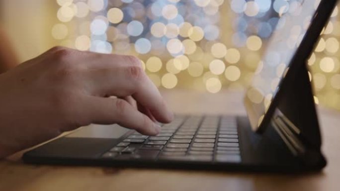 一名穿着针织毛衣的男子在数字平板电脑上工作