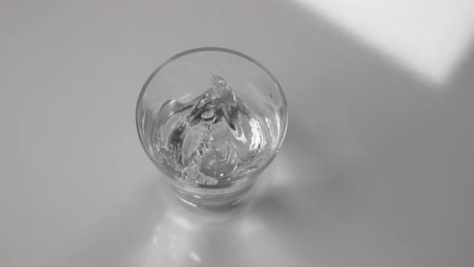 特写: 地震期间，透明玻璃内的水溢出。