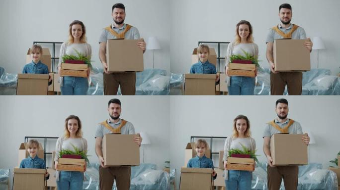 男人和小女孩幸福的家庭在搬迁到新公寓时拿着箱子