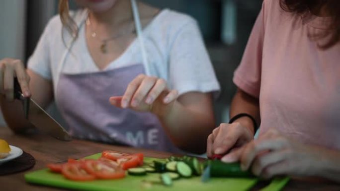 2位亚洲华人姐妹在餐厅里度过了亲密的时光，准备早餐食物快乐地交谈