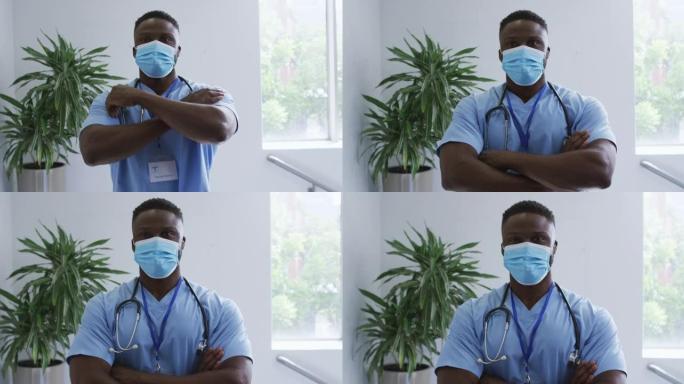 非裔美国男医生戴着磨砂膏和口罩，在医院交叉双臂的肖像