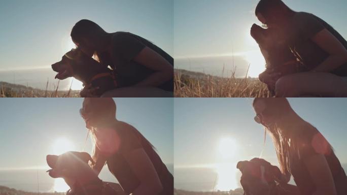 4k视频片段，一个无法识别的女人在与狗一起远足时看着日落