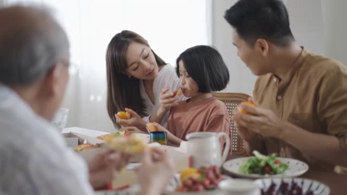 幸福的家庭享受假期在家中的午餐时间吃饭