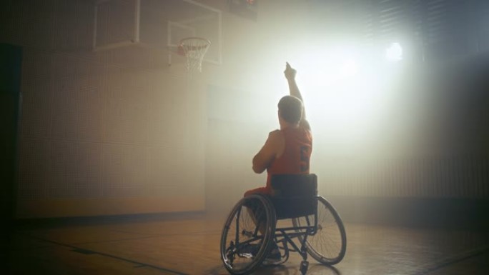 轮椅篮球运动员穿着红色制服的投篮成功，打进了一个完美的进球。残疾人的决心、训练、灵感。暖色静态宽幅镜