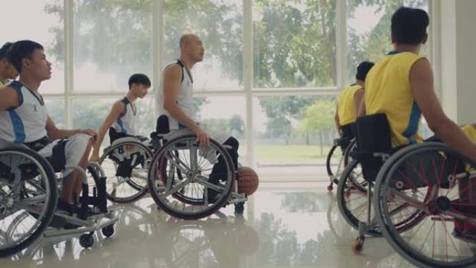 男子轮椅篮球队将轮椅推入练习场。