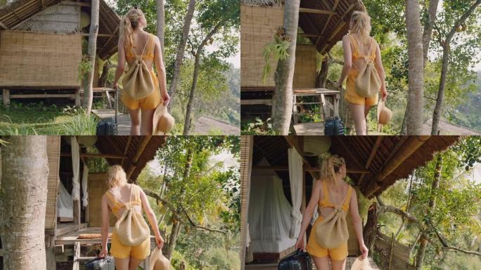 带着手推车包的旅行女人在异国情调的暑假到达热带酒店度假胜地，步行到小屋