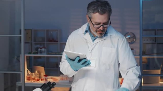 实验室工作人员使用平板电脑和培养皿与实验室种植的肉