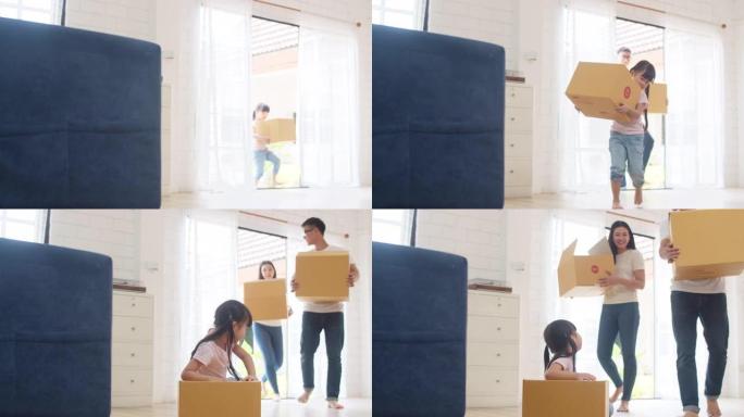 日本妈妈、爸爸和孩子微笑快乐地拿着纸板箱，移动物体走进家。