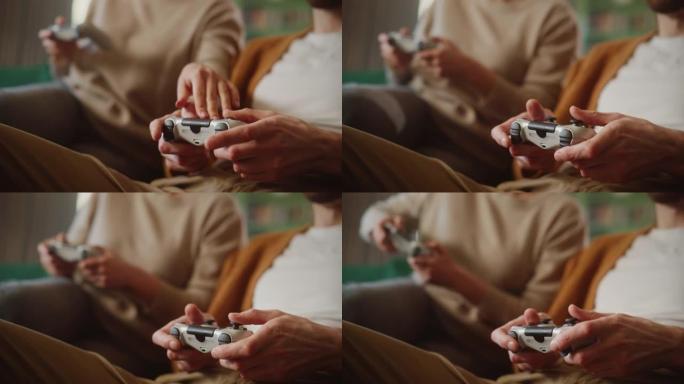 幸福的夫妇坐在沙发上玩电子游戏，使用控制器。恋爱中的竞争女友和男友在家里一起玩在线视频游戏。近距离聚
