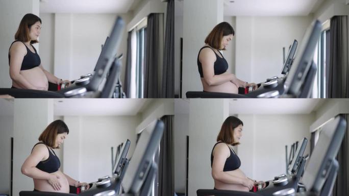 孕妇在健身室锻炼，在跑步机上行走，身体健康和有氧运动