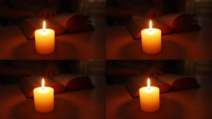 在家中的木桌上用烛光阅读圣经