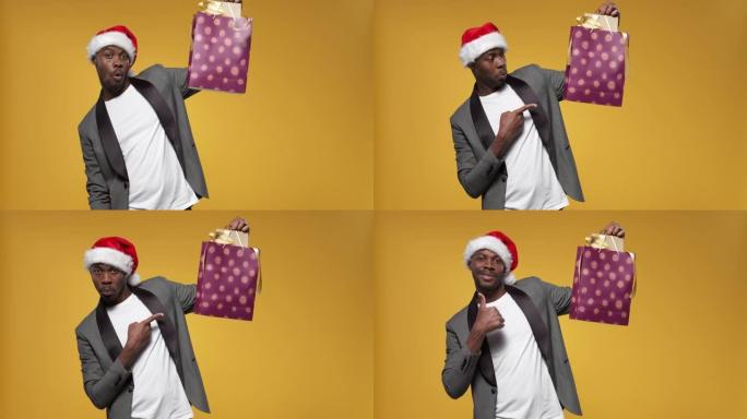 一个戴着圣诞帽和灰色夹克的黑皮肤男人举起双手，用带有礼品盒的包裹