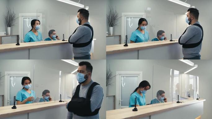戴着面具的亚洲接待员帮助医院受伤的病人