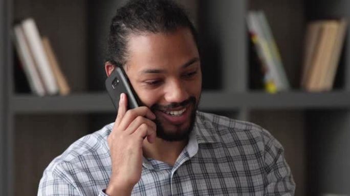 非洲企业家坐在工作场所通过电话与客户交谈