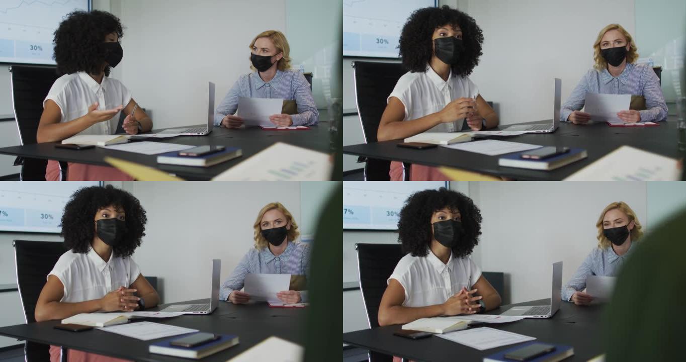 戴着面具的非裔美国妇女在会议室发表演讲