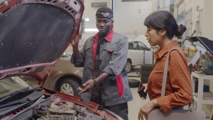汽车修理工向女性客户解释汽车故障