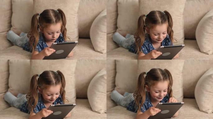 积极的小7s女孩在数字平板电脑上玩。