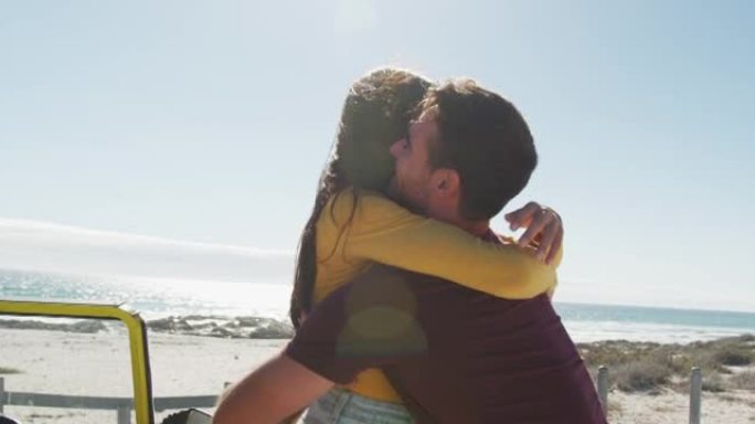快乐的高加索夫妇在海边的沙滩车附近拥抱