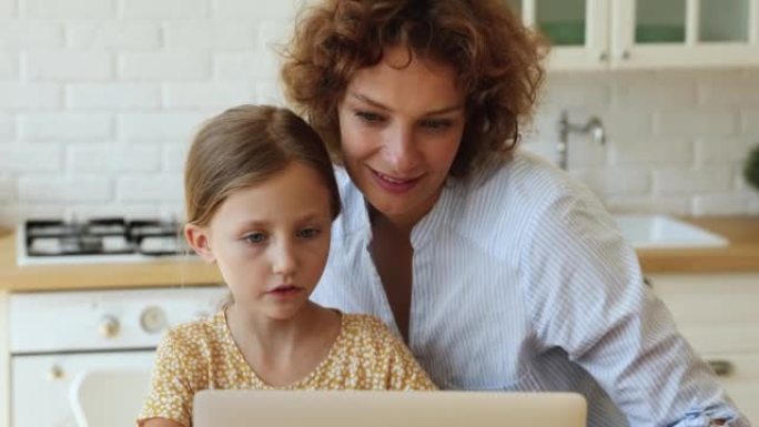 快乐可爱的小女孩喜欢和妈妈在网上做作业。