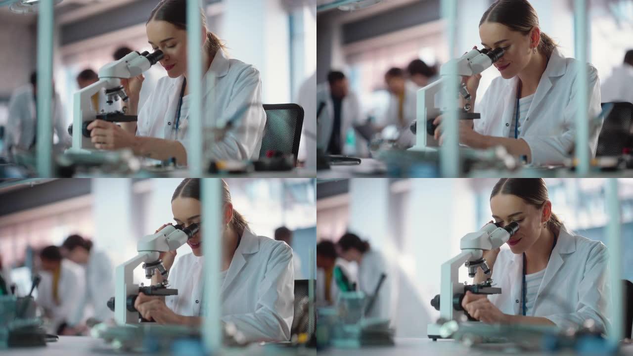 年轻的专业女工程师在实验室中使用显微镜检查电气组件的肖像。在一家工业制造公司担任实验室专家的成功女性