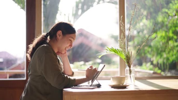 亚洲女商人在餐厅使用笔记本电脑打字独自坐在桌子旁工作