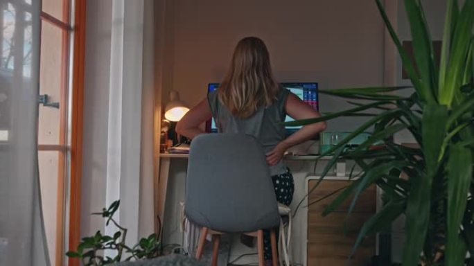 女人在电脑上工作时伸展身体