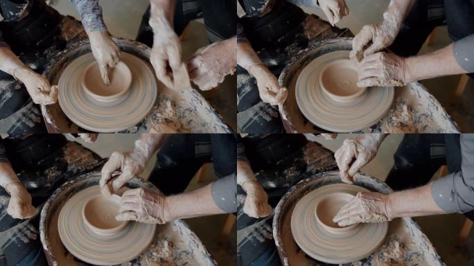 成人和儿童用陶轮上的粘土制作陶瓷碗的特写