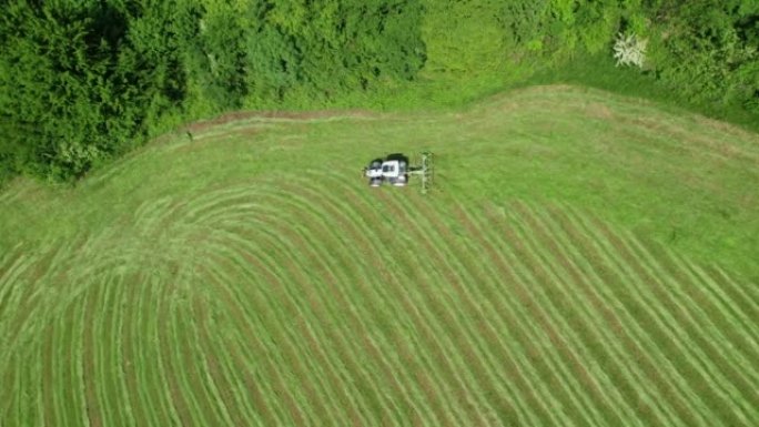 空中，自上而下: 使用干草的拖拉机快速干燥新鲜割草