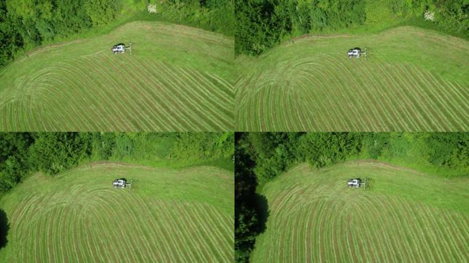 空中，自上而下: 使用干草的拖拉机快速干燥新鲜割草