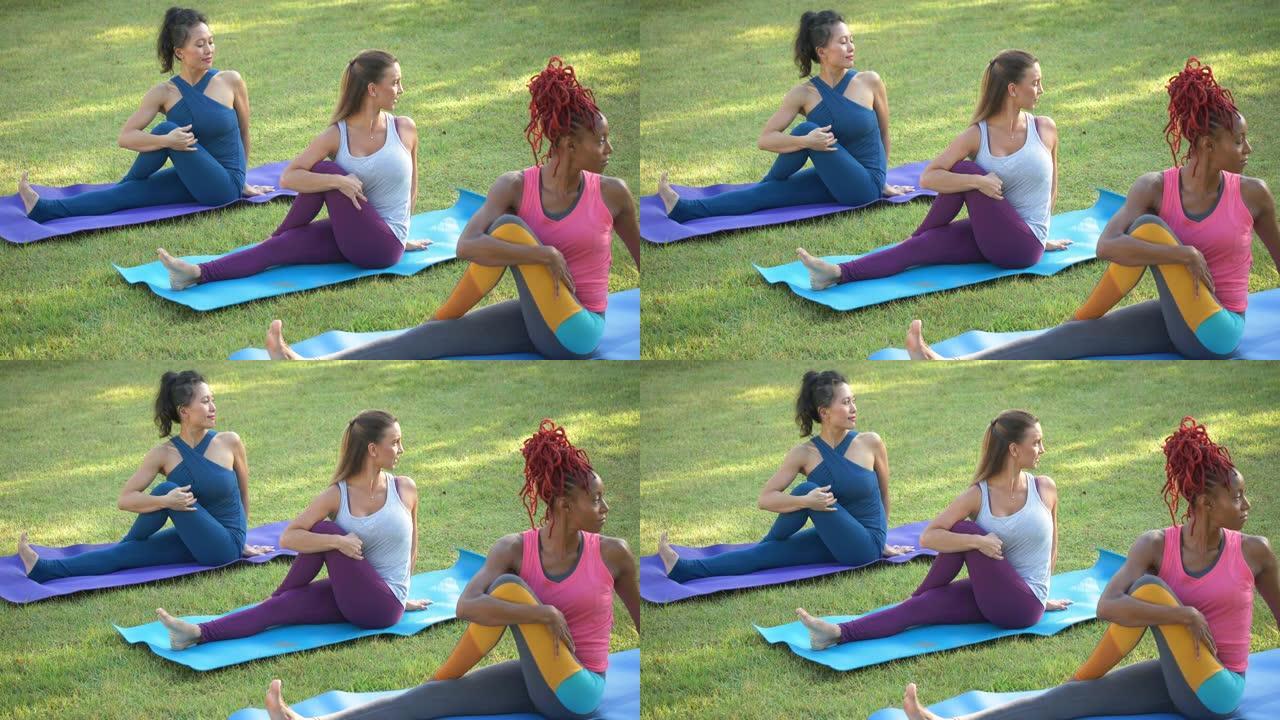 三个女人在户外练习瑜伽，半脊椎扭转