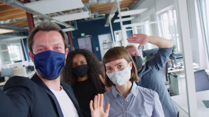 带口罩的创业团队在办公室自拍