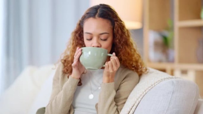 女人在家喝一杯热茶或咖啡。无忧无虑、轻松开朗的年轻女性一边啜饮一边享受着新鲜温暖饮料的香气，一边在家