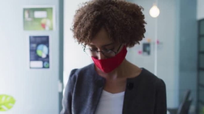 现代办公室戴着口罩手持温度枪的非洲裔美国妇女的肖像