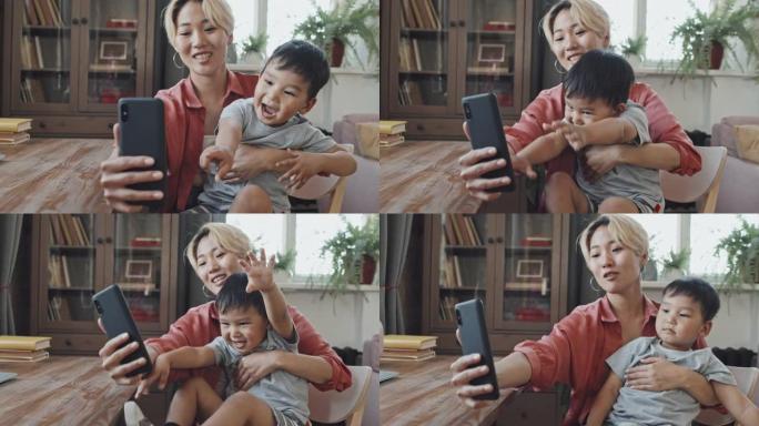 亚洲母亲和小儿子在智能手机上自拍