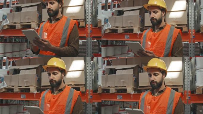 在仓库中使用平板电脑的安全帽工人