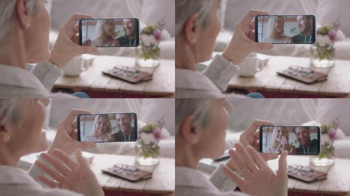 成熟的女人使用智能手机与幸福的夫妇聊天，在手机屏幕上与祖母分享激动人心的订婚，享受家庭联系4k