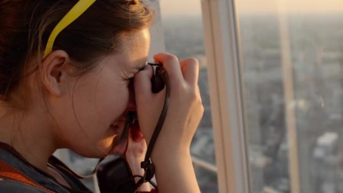 4k视频片段，一位迷人的年轻女子在乘坐摩天轮时拍照