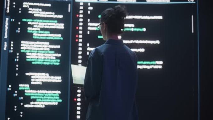 女人创建软件和编码的后视图，周围是大屏幕，显示编程语言代码行。在监控控制室工作的女程序员。未来主义概