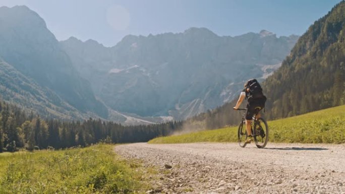 SLO MO自行车手在山下的乡间小路上骑行