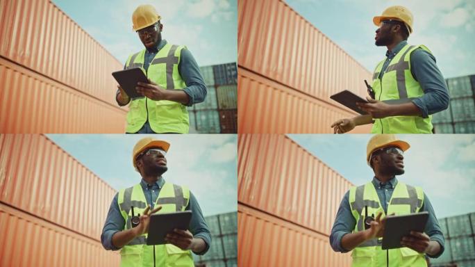 一位穿着黄色安全帽和安全背心的英俊非洲裔美国黑人工业工程师在平板电脑上工作的微笑肖像。集装箱码头的检