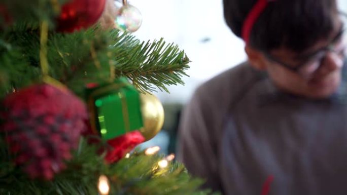 4K UHD多莉拍摄特写亚洲幸福家庭装饰圣诞树与装饰品一起准备快乐假期冬天。
