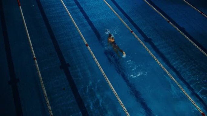 女子游泳运动员在游泳池里比赛。职业运动员决心用蝶式赢得冠军。深色戏剧性的颜色，电影圈车道灯。空中静力