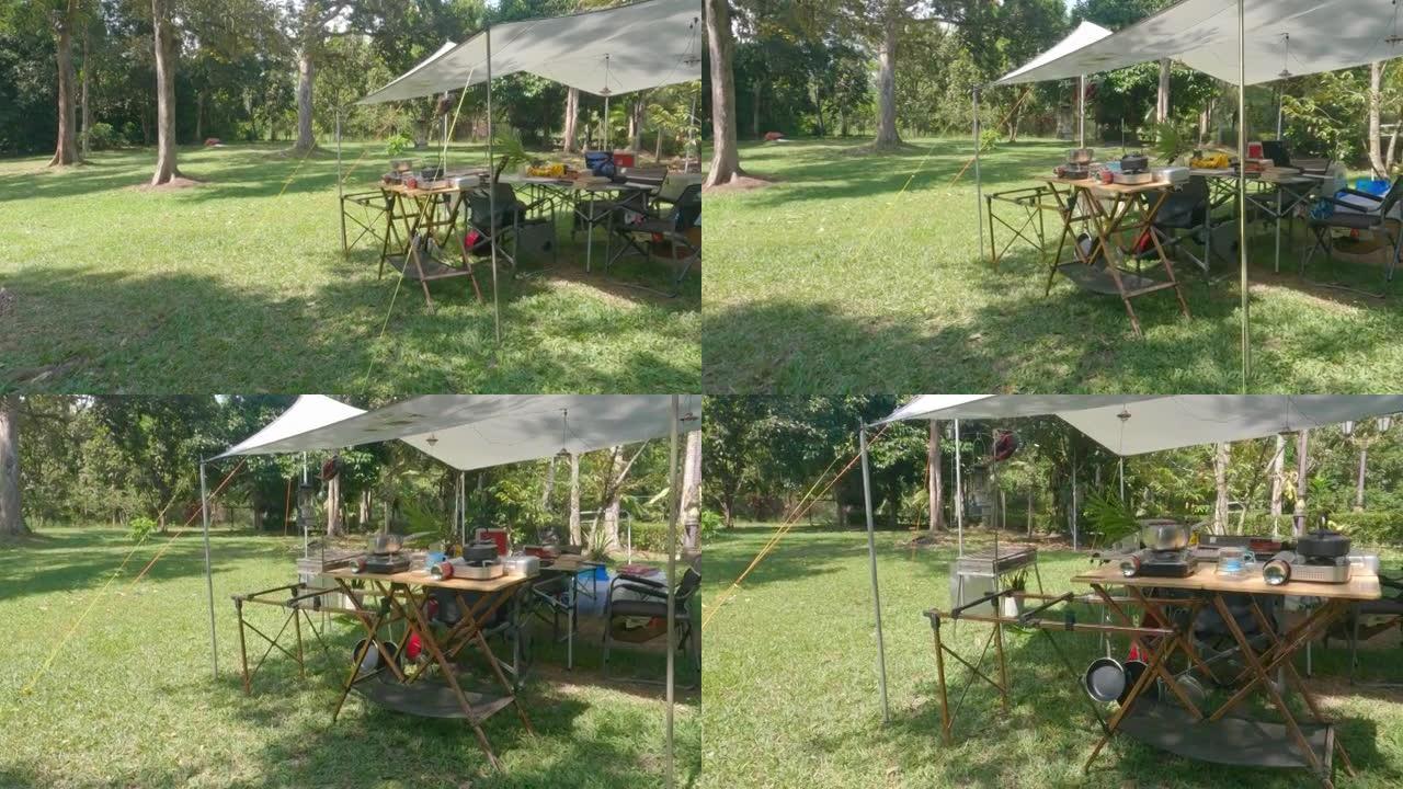 夏季野营设施，配有帐篷、桌子、椅子和烹饪用具