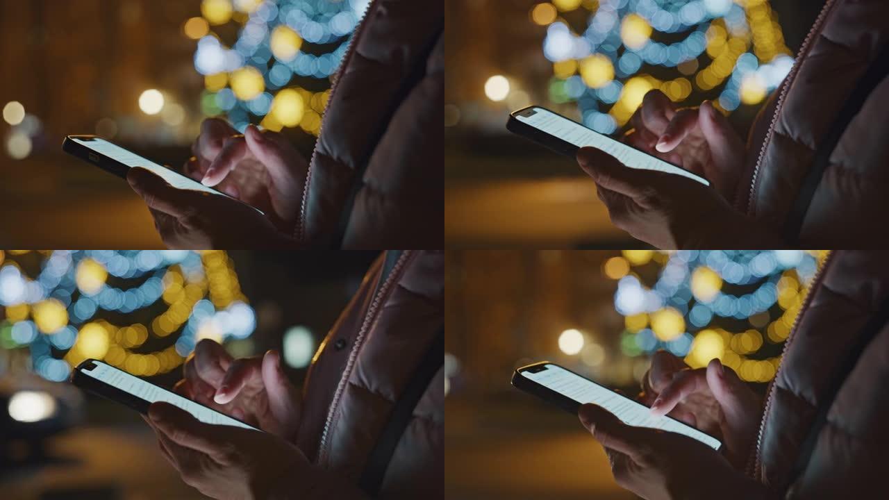 DS无法识别的人在节日灯火照亮的城市中使用智能手机